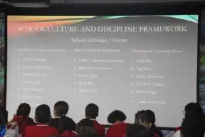 Students view a presentation slide about school activities and events.
