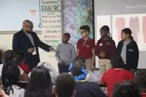 Four students join a staff member during a discussion about school uniforms.
